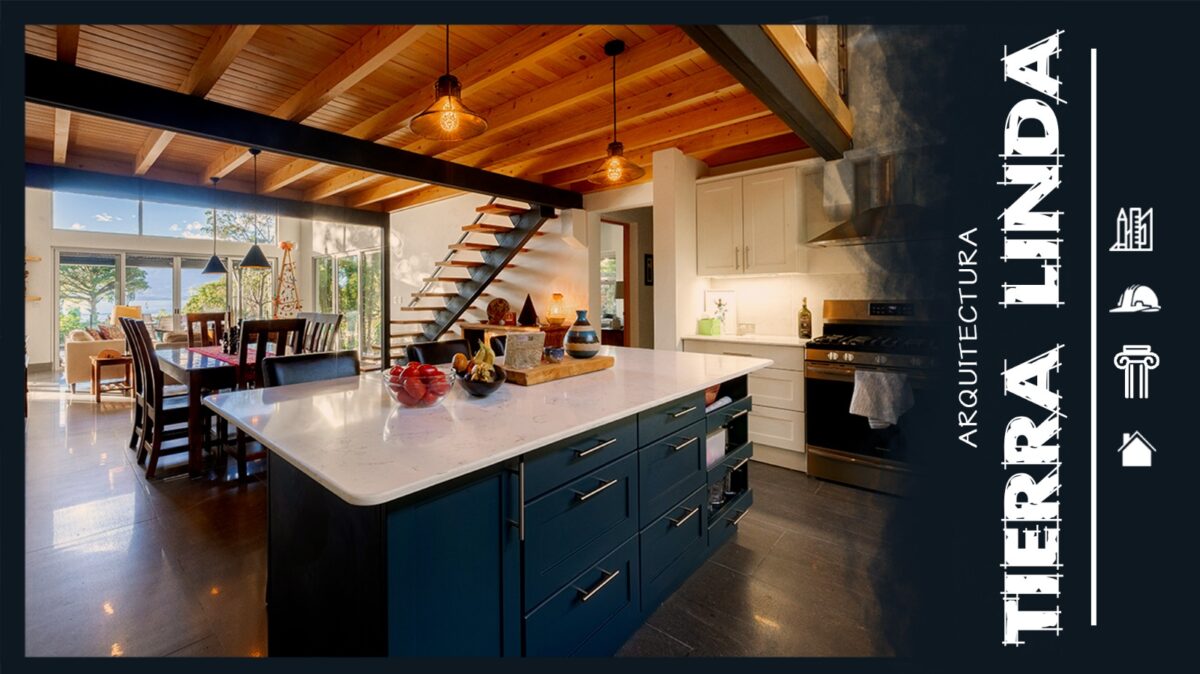 Stylish kitchen with an island, dark blue cabinets, wooden beams, and a dining area, featuring large windows and natural light.